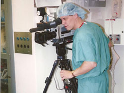 Man in scrubs using video camera